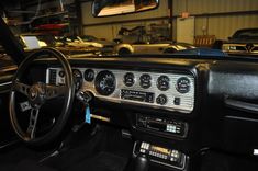 the interior of an old car with gauges and dash boards on display in a garage