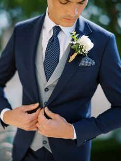 a man wearing a suit and tie with a boutonniere on his lapel