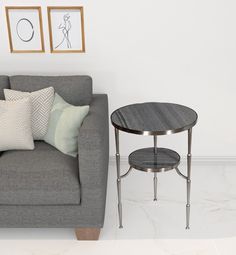 a grey couch sitting next to a table on top of a white floor