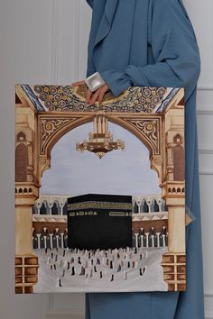 a man holding up a painting in front of a doorway with an image of the kabab