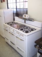 a white stove top oven sitting inside of a kitchen