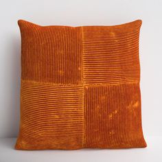 an orange velvet pillow sitting on top of a white table