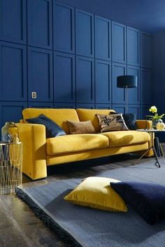 a living room with blue walls and yellow couches in the middle of the room