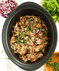 a bowl filled with meat and garnished with herbs