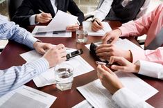 people sitting around a table with papers and cell phones