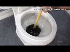 someone is using a plunger to clean a toilet bowl with water and black substance