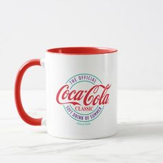 a red and white coffee mug with the coca cola classic logo