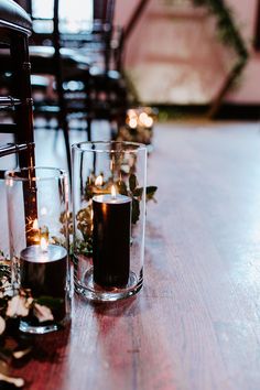 candles are lined up on a wooden table