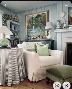 a living room filled with furniture and a painting on the wall above it's fireplace