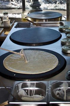 an outdoor cooking area with pots and pans on the stove, water being poured from a faucet