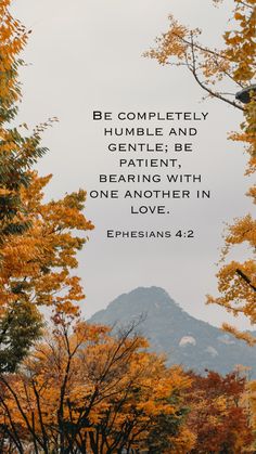 the bible verse is shown in front of trees with yellow leaves and mountains behind it