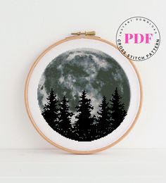 a cross stitch pattern with trees and the moon