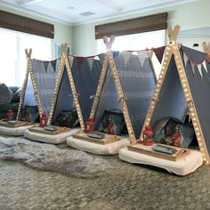 three tents with lights on them are sitting in the middle of a carpeted room