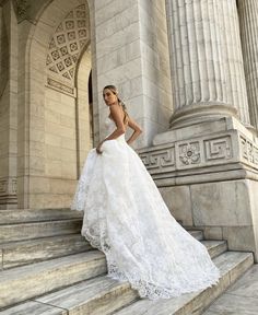 a woman in a wedding dress standing on some steps