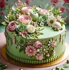 a green cake with pink and white flowers on it