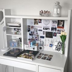 a white desk topped with lots of pictures and magnets on it's side