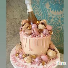 a birthday cake decorated with seashells and a bottle of champagne on the top