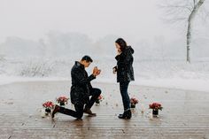 a man kneeling down next to a woman in the snow