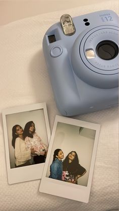 two polaroid cameras sitting next to each other on a bed