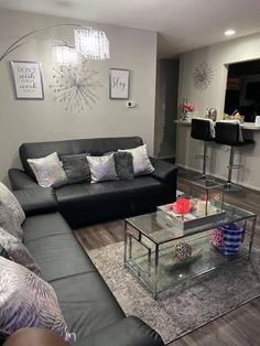 a living room filled with furniture and a glass table in front of the couches