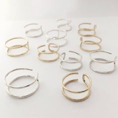 six pairs of silver and gold rings on a white surface with one ring in the middle