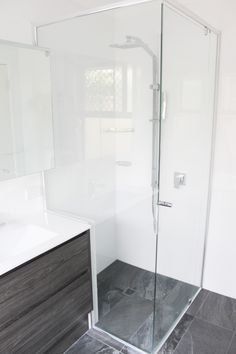 a bathroom with a walk in shower next to a sink