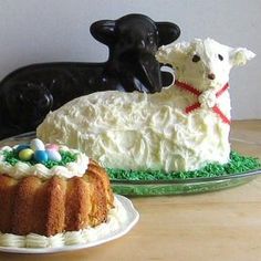 two cakes decorated with sheep and lambs on plates