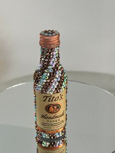 a bottle that is sitting on a table with some kind of beads in the top