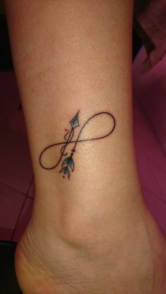 a small tattoo on the foot of a woman with an arrow in it's center