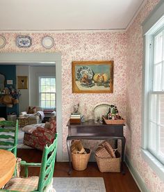 a living room filled with furniture and a painting on the wall next to a window