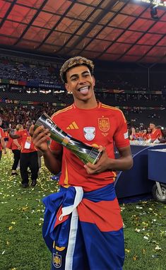 a soccer player holding a trophy in his hand