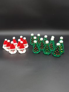 three small christmas decorations are sitting next to each other on a black surface with white and red dots