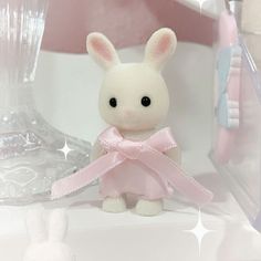 a white stuffed rabbit sitting on top of a counter next to a toothbrush and tube