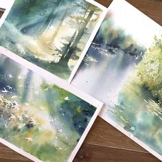 four watercolor paintings are shown on a table