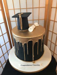 a graduation cake decorated with icing and a mortaron on top is sitting on a table