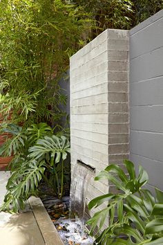 a water feature in the corner of a garden