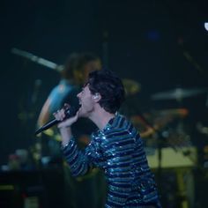 a woman singing into a microphone on stage