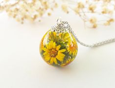 This listing is for a lightweight lovely botanical pendant of a bouquet of wildflowers in jeweler's grade eco resin.   All flowers have been carefully placed in hand poured resin, done in many steps, to give this a colorful, natural garden appearance. ❋The ball is 2 cm (0.8 inch) diameter ❋Necklace comes with a hypoallergenic Stainless Steel chain. Please choose the chain size when buying. ❋Every piece in this shop was made in several casting steps, sanded and polished by hand. ❋Colours may vary slightly from the picture. There might be slight imperfections like bubbles and uneven surfaces . The imperfections are what give the jewellery depth and character. ❋Each finished jewelry listing will arrive ready to gift in a gift box ❋Any questions please feel free to ask :) Bouquet Of Wildflowers, Real Flower Necklace, Terrarium Necklace, Pressed Flower Necklace, Jewelry Nature, Real Flower Jewelry, Eco Resin, Daisy Necklace, Resin Flowers