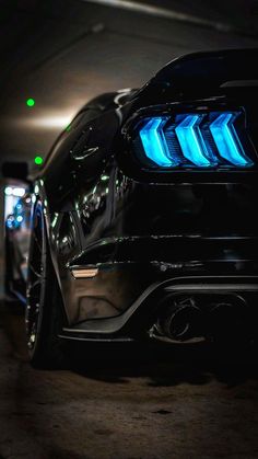 the front end of a black car with blue lights