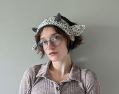 a woman wearing glasses and a crocheted hat