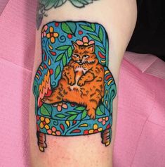 an orange cat sitting on top of a blue chair with leaves and flowers around it