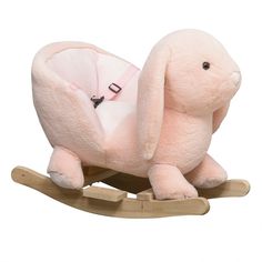 a pink stuffed animal sitting on top of a wooden rocking toy