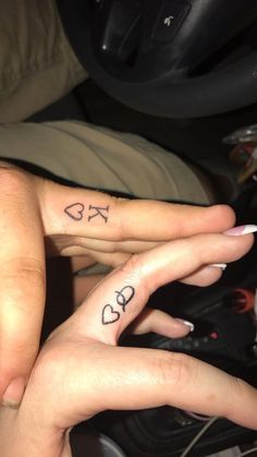 two people with matching tattoos on their fingers