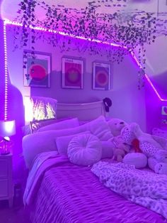 a bedroom with purple lighting and stuffed animals on the bed