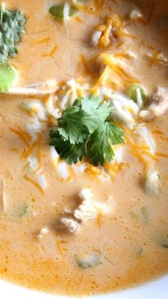 a close up of a bowl of soup with broccoli and cheese on top