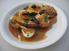 a white plate topped with food covered in gravy on top of a table