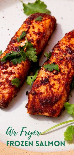 two pieces of grilled fish on a plate with corian and parsley garnish