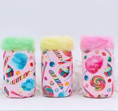 three jars with different designs on them sitting next to each other in front of a white background