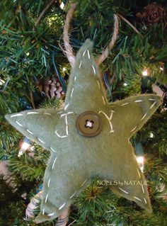 a star ornament hanging from a christmas tree