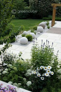 a garden with flowers and rocks in the center, surrounded by greencube plants